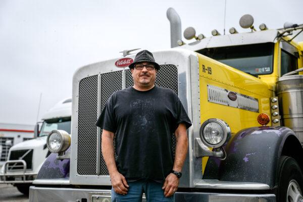 Truck driver Gus Valudes stands next to his rig at the TA Truck Service truck stop in London, Ohio, on March 19, 2020. (Charlotte Cuthbertson/The Epoch Times)
