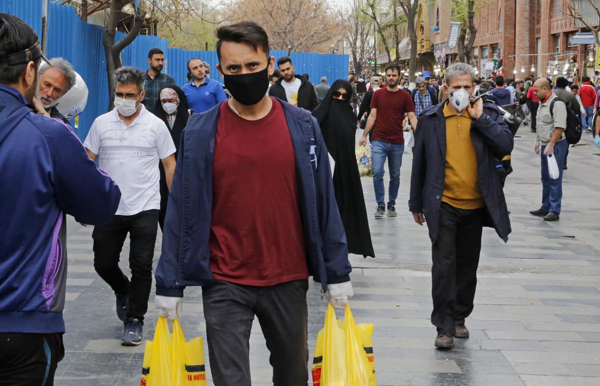 Iranians, some wearing protective masks, walk outside the capital Tehran's grand bazaar, during the CCP Virus pandemic crisis, on March 18, 2020. (-/AFP via Getty Images)