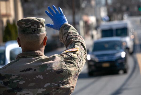A U.S. National Guard soldier stops traffic as fellow troops distribute food to local residents at the WestCop community center in New Rochelle, New York, on March 18, 2020. (John Moore/Getty Images)