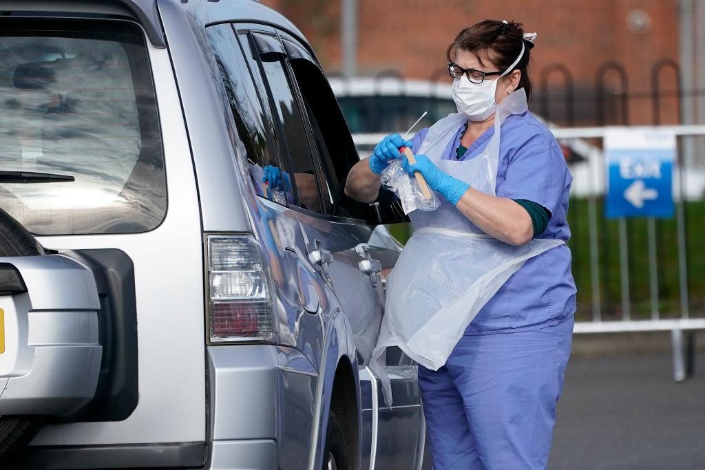 A member of the public is swabbed at a drive-through coronavirus testing site, set up in a car park, on March 12, 2020, in Wolverhampton, England.  (©Getty Images | <a href="https://www.gettyimages.com/detail/news-photo/member-of-the-public-is-swabbed-at-a-drive-through-news-photo/1211955523">Christopher Furlong</a>)