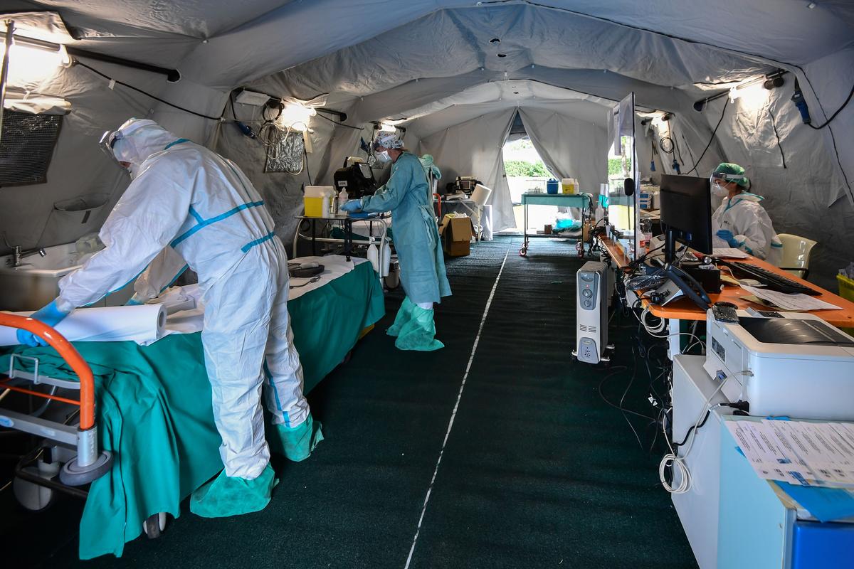 Hospital staff work in a patients' triage tent at a temporary emergency structure at the Brescia hospital in Lombardy on March 13, 2020. (©Getty Images | <a href="https://www.gettyimages.com/detail/news-photo/hospital-workers-wearing-protective-mask-and-gear-work-in-a-news-photo/1206921540?adppopup=true">MIGUEL MEDINA</a>)