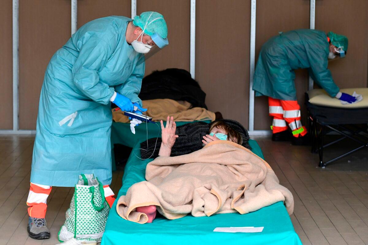 <span class="s1">A hospital employee tends to a patient at a temporary emergency facility set up to screen patients with COVID-19 symptoms at the Brescia hospital, in Lombardy, Italy, on March 13, 2020. (Miguel Medina/AFP/Getty Images)</span>