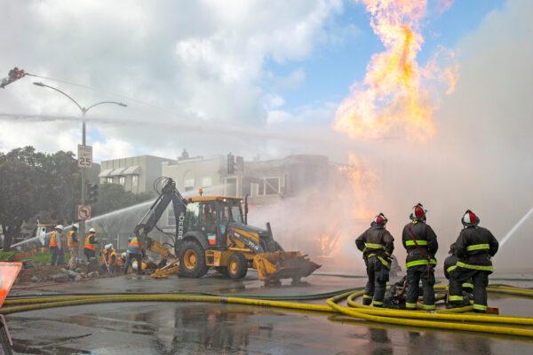 Firefighters battle a fire following an explosion at Geary Boulevard and Parker Avenue as PG&E officials dig up the ground to reach the pipe in San Francisco, Calif., on Feb. 6, 2019. (Santiago Mejia/San Francisco Chronicle/Reuters)