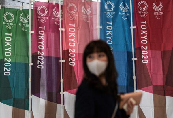 A woman walks past Tokyo 2020 Olympics banners in Tokyo, Japan, on March 19, 2020. (Carl Court/Getty Images)