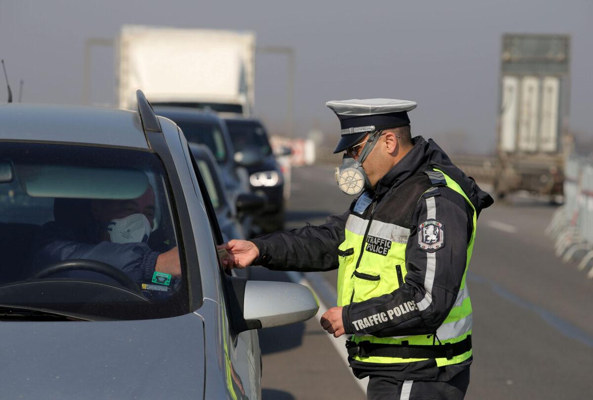 A police officer checks a car driver at one of the exits of Sofia, following restrictions on non-essential travel between cities and towns, in an attempt to prevent the spread of the CCP virus in Bulgaria on March 21, 2020. (Dimitar Kyosemarliev/Reuters)