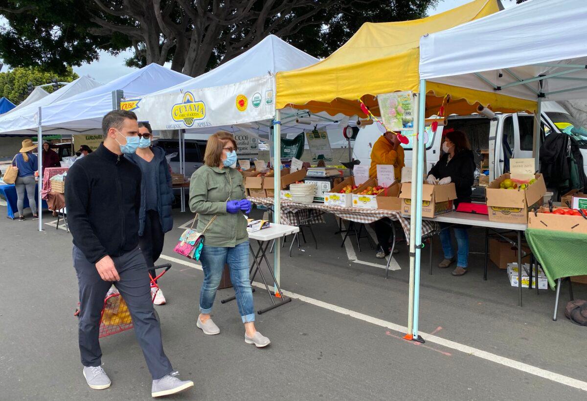 Customers and sellers alike wear masks at the Farmer's Market in Mar Vista, Calif., on March 22, 2020. (Chris Delmas/AFP via Getty Images)