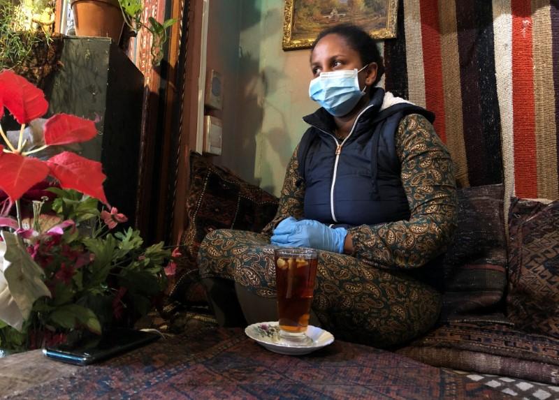 A woman wears a mask and gloves as a measure to combat the spread of the CCP virus at a restaurant in Cape Town, South Africa, on March 20, 2020. (Sumaya Hisham/Reuters)