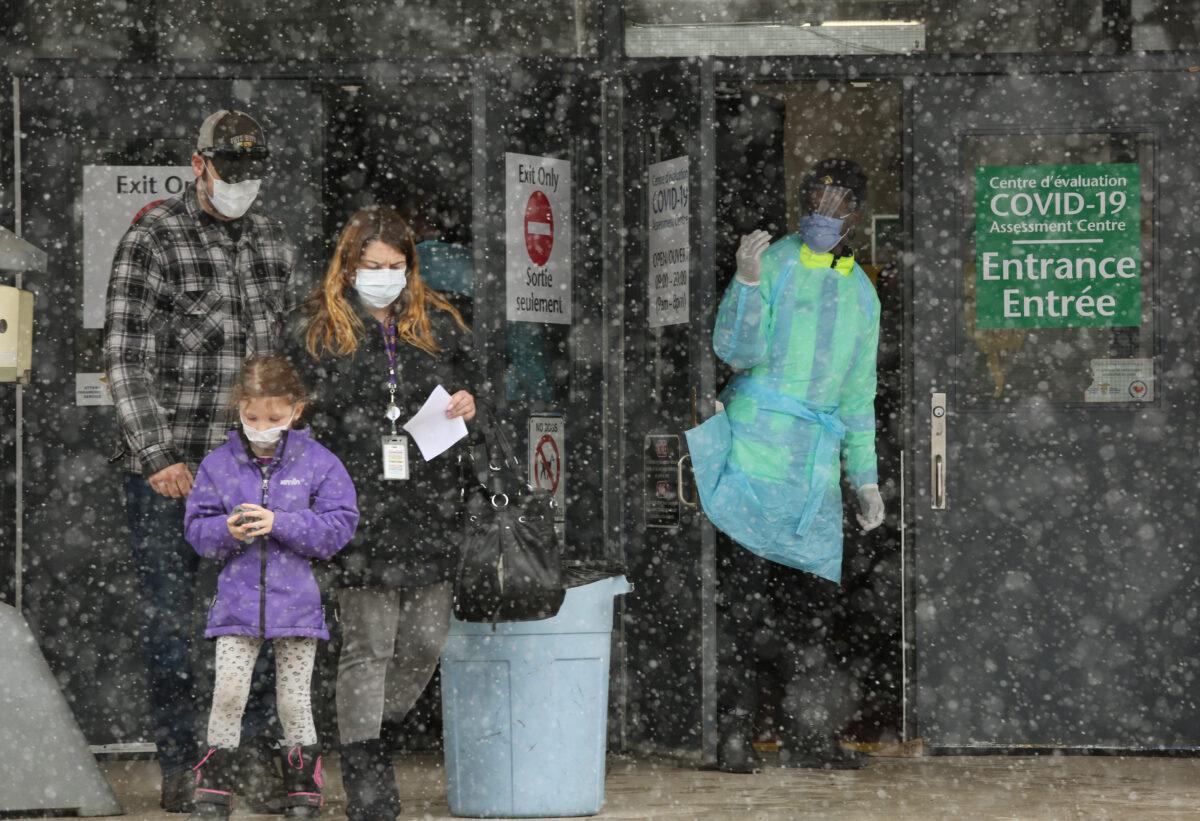 An Ottawa Public Health officer (R) waves to the next person in line at the COVID-19 testing center in Ottawa, Canada, on March 23, 2020. (Dave Chan/ AFP via Getty Images)