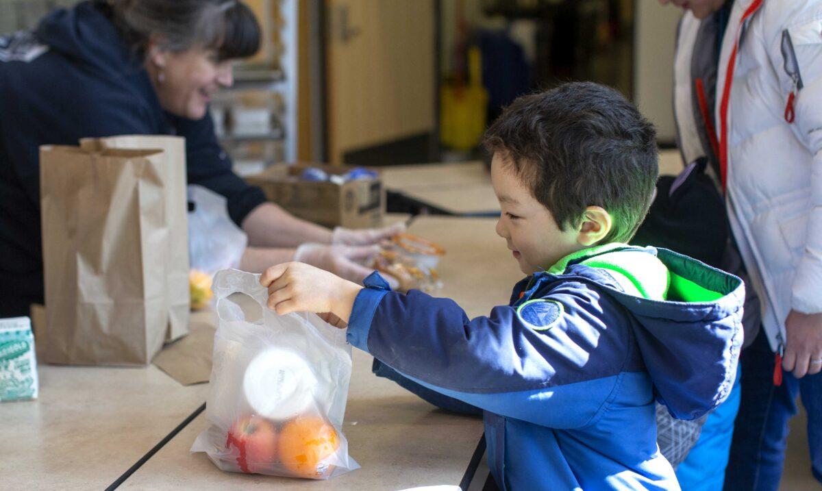 Tyden Brownlee, 5, picks up a free school lunch at Olympic Hills Elementary School in Seattle on March 18, 2020. (Karen Ducey/Getty Images)