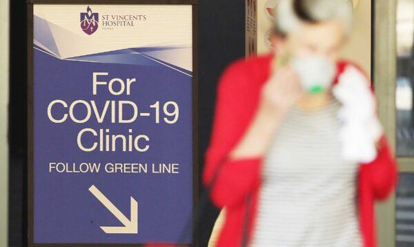 People pass signs for a COVID-19 clinic as they enter or exit St. Vincent's hospital in Sydney, Australia, on March 18, 2020. (Mark Metcalfe/Getty Images)