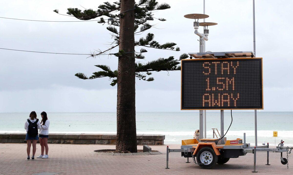 A sign reminding residents and tourists of new social distancing rules is displayed at Manly Beach in Sydney, Australia, on March 23, 2020. (Cameron Spencer/Getty Images)