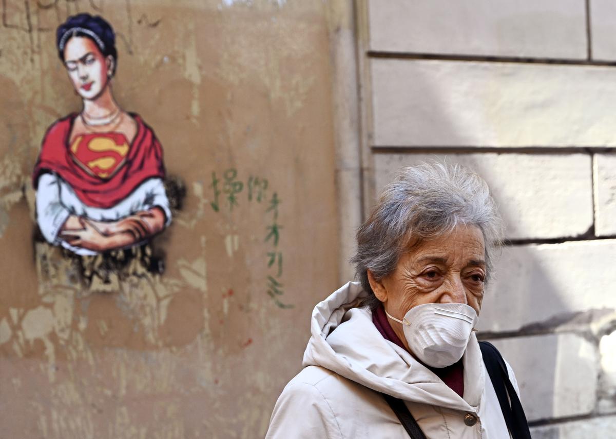 A woman wearing a mask walks through the Jewish district in central Rome, Italy, during the country's lockdown aimed at stopping the spread of the COVID-19 pandemic, in Rome, Italy, on March 24, 2020. (Vincenzo Pinto/AFP via Getty Images)