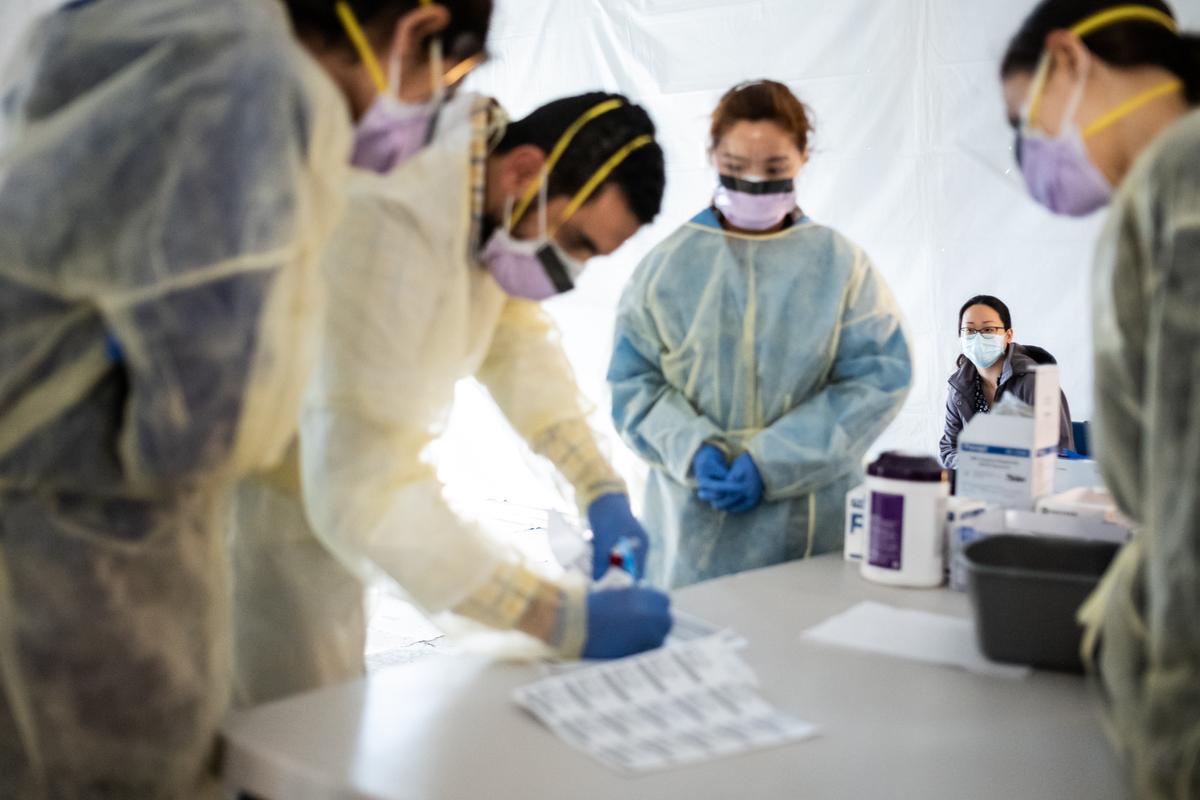 Doctors test hospital staff with flu-like symptoms for the CCP virus in tents set up to triage possible COVID-19 patients outside before they enter the main emergency department area at St. Barnabas hospital in the Bronx borough of New York City on March 24, 2020. (Misha Friedman/Getty Images)