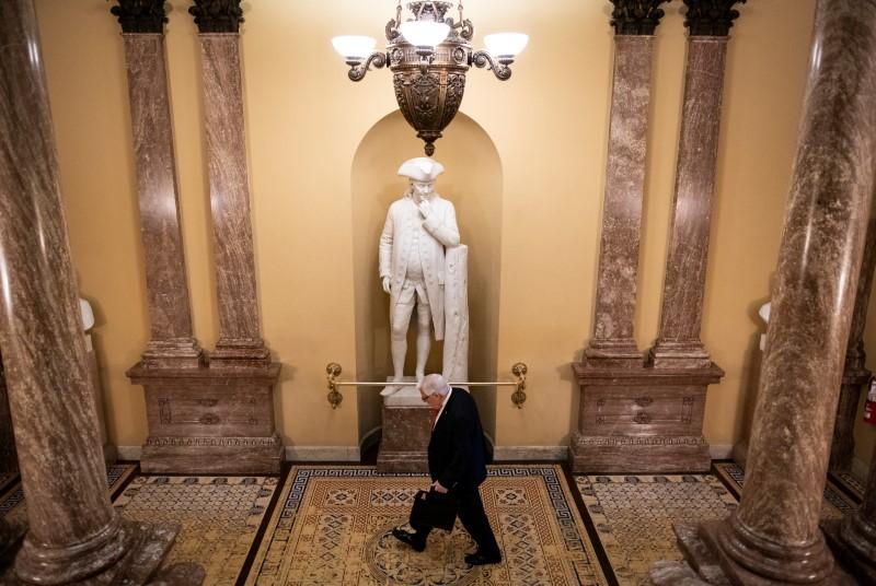 Senator Mike Enzi (R-WY) walks past a statue of Benjamin Franklin in the U.S. Capitol in Washington, on March 24, 2020. (Reuters/Al Drago)