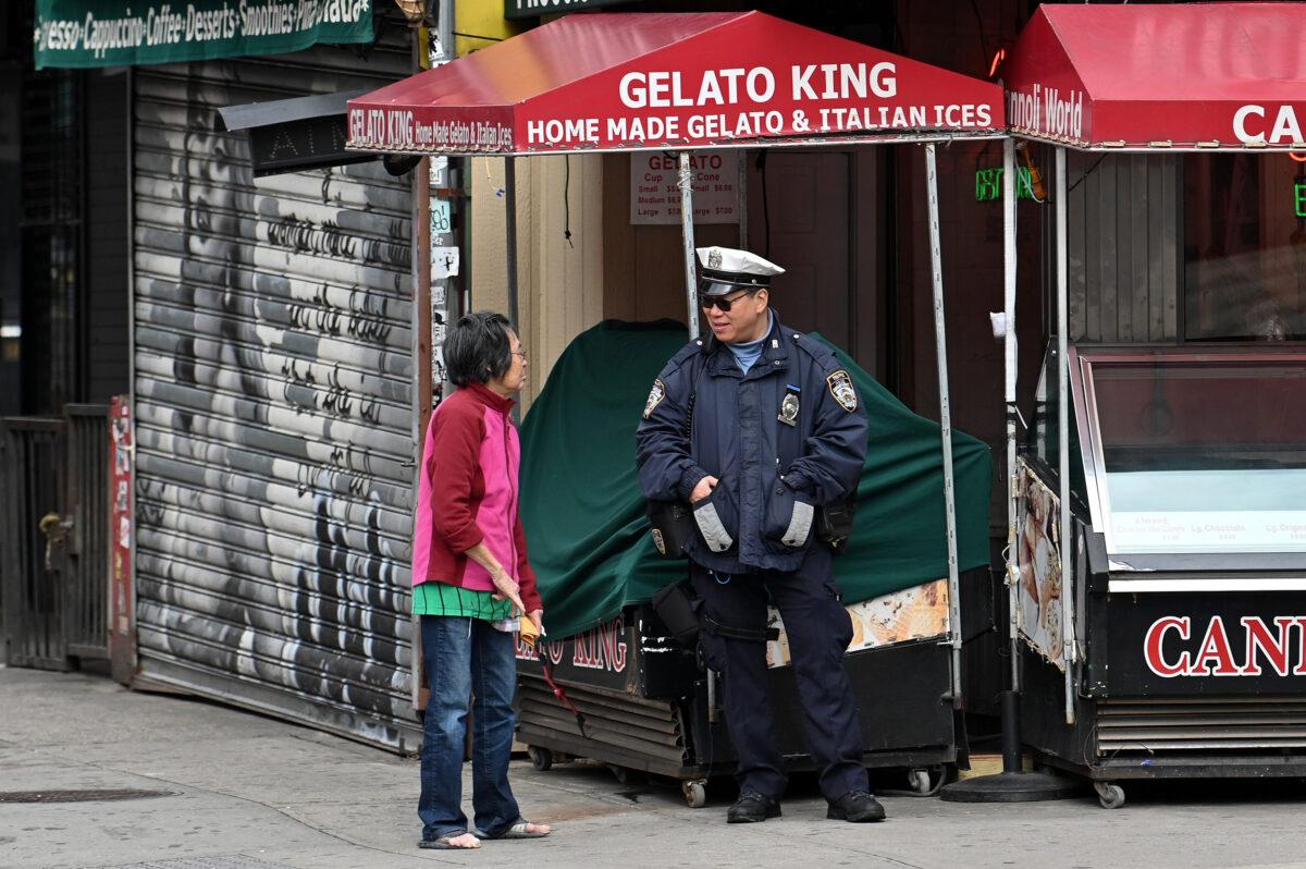 A woman speaks to a NYPD Traffic Enforcement Agent on an empty street corner in Manhattan's Little Italy as the coronavirus continues to spread across the United States in New York City on March 17, 2020. (Dia Dipasupil/Getty Images)
