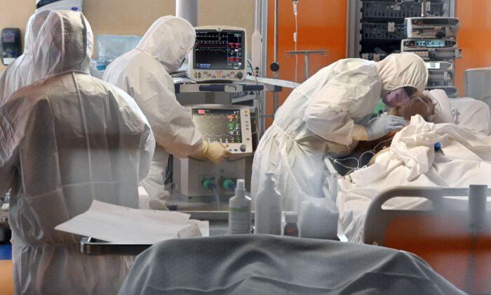 A medical worker in protective gear (R) tends to a patient on March 24, 2020, at the new COVID 3 level intensive care unit. (©Getty Images | <a href="https://www.gettyimages.com/detail/news-photo/medical-worker-in-protective-gear-tends-to-a-patient-on-news-photo/1208081043?adppopup=true">ALBERTO PIZZOLI</a>)