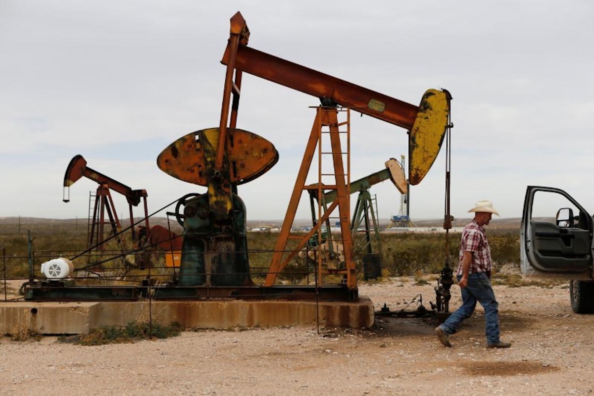 Paul Putnam, 53, a rancher and independent contract pumper walks past a pump jack in Loving County, Texas, on Nov. 25, 2019. (Angus Mordant/Reuters)