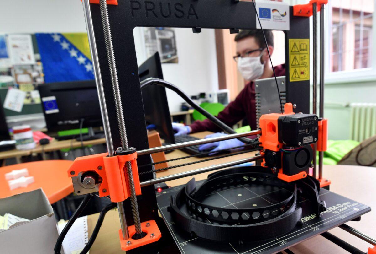 A mechanical engineering student monitors 3D printers making protective equipment in Zenica, Bosnia, on March 25, 2020. (Elvis Barukcic/AFP via Getty Images)