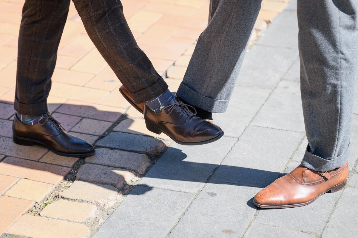 Businessmen perform a footshake, tapping their shoes against each other on March 18, 2020, in Christchurch, New Zealand. (Kai Schwoerer/Getty Images)
