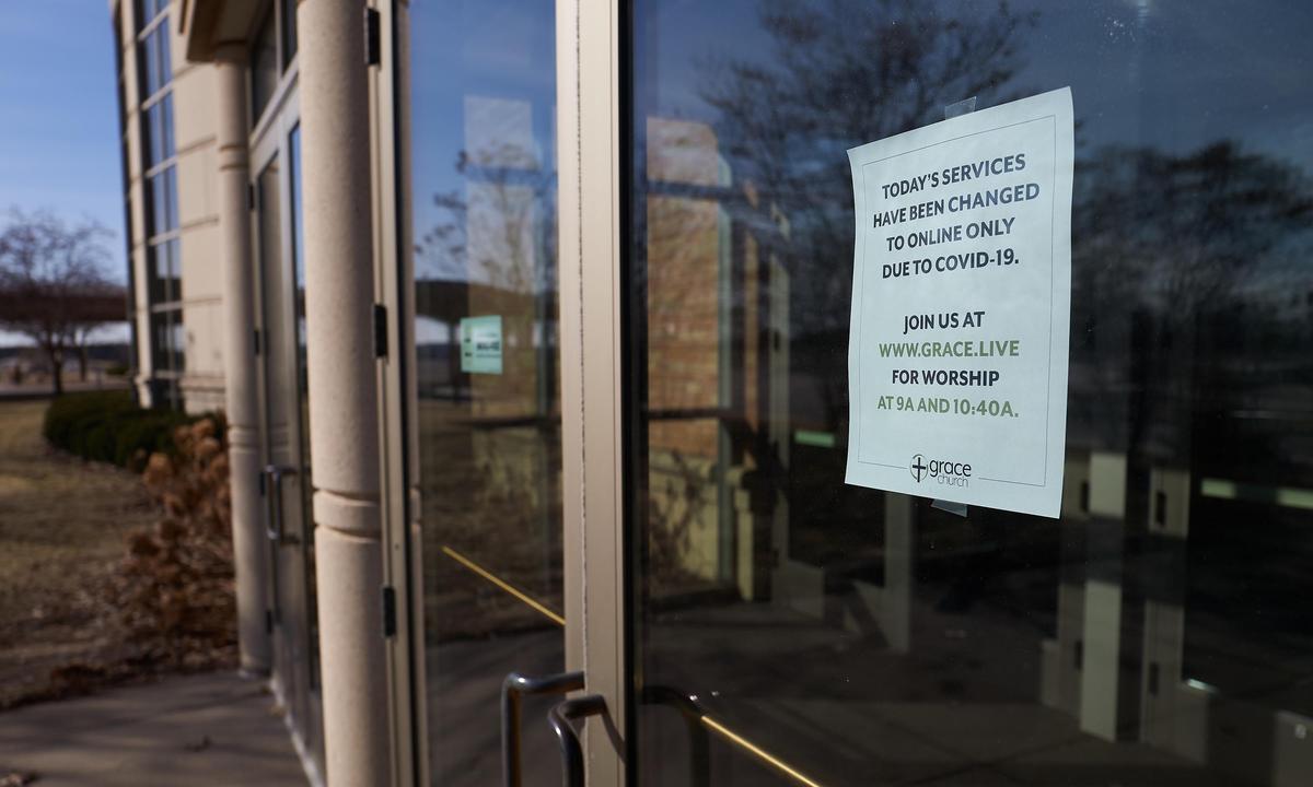 A sign on the door to Grace Church Eden Prairie pointed churchgoers to online services after church leadership decided to present worship music and the sermon to an estimated 3,500 online viewers in Eden Prairie, Minnesota, on March 15, 2020. (Adam Bettcher/Getty Images)