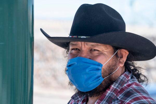 Jose Vera, 53, who is traveling to Colorado from Zacatecas, Mexico, wears a mask as a precautionary measure against COVID-19 while waiting for his bus to cross the U.S.-Mexico border in El Paso, Texas, on March 20, 2020. (Paul Ratje/AFP via Getty Images)