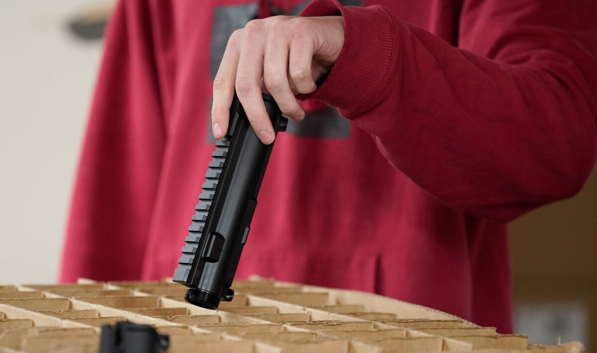 A worker unpacks parts for an AR-15 rifle at Delta Team Tactical in Orem, Utah, on March 20, 2020. (George Frey/AFP via Getty Images)