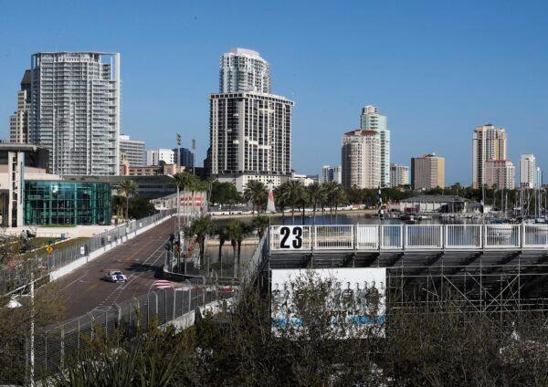 The grandstands are empty as cars make their way around past the Mahaffey Theater and head towards turn 10 during the opening day of the Firestone Grand Prix of St. Petersburg in St. Petersburg, on March 13, 2020. (Dirk Shadd/Tampa Bay Times via AP)