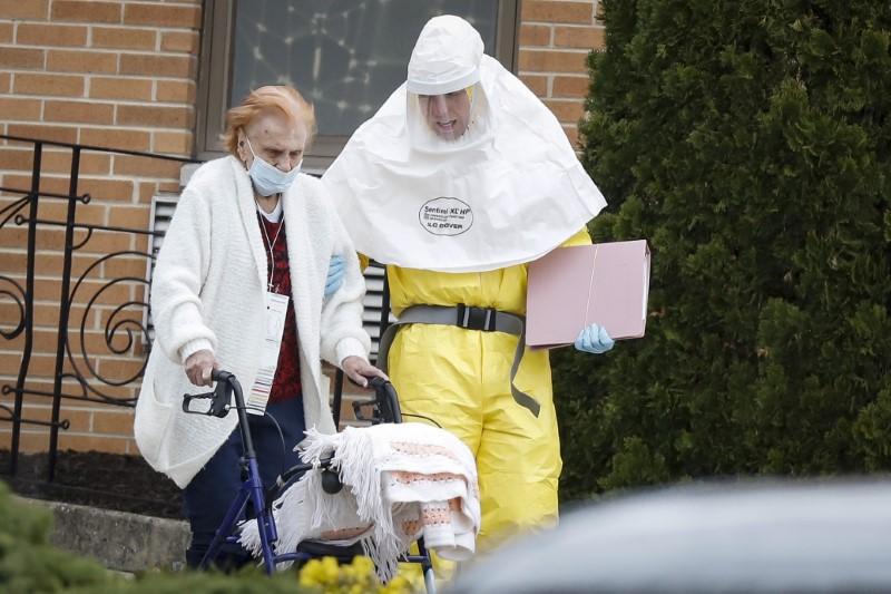 Medical officials aid a resident from St. Joseph's nursing home to board a bus, after a number of residents tested positive for the CCP virus in Woodbridge, New Jersey on March 25, 2020. (Stefan Jeremiah/Reuters)