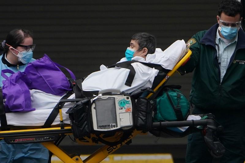 Paramedics move a patient into the hospital during the outbreak of the CCP virus in the Manhattan borough of New York City, New York on March 25, 2020. (Carlo Allegri/Reuters)