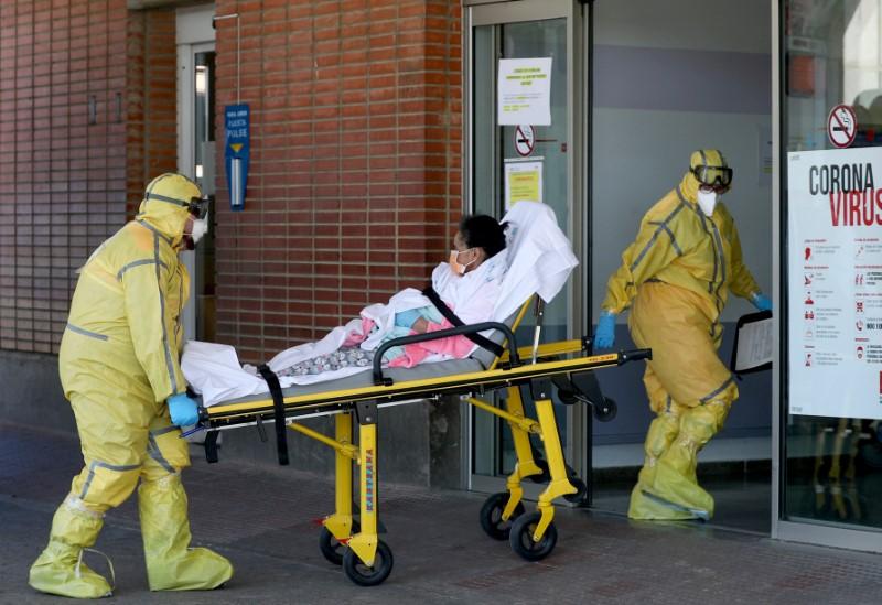 Ambulance workers in full protective gear arrive with a patient at the Severo Ochoa Hospital during the COVID-19 outbreak in Leganes, Spain on March 26, 2020. (Susana Vera/Reuters)