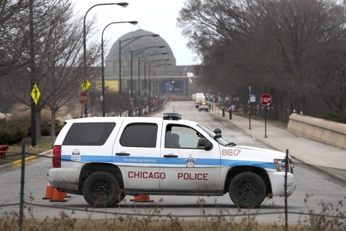 A Chicago police officer blocks the road to the Adler Planetarium along Lake Michigan in Chicago on March 26, 2020. (Charles Rex Arbogast/AP Photo)