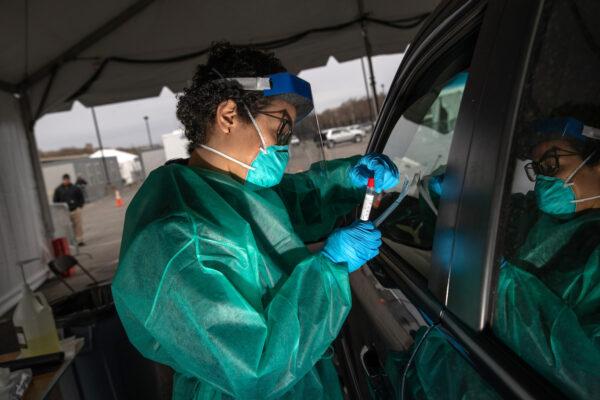 A health worker handles a coronavirus swab test at a drive-thru testing center for COVID-19 at Lehman College in the Bronx, New York, on March 28, 2020. (John Moore/Getty Images)