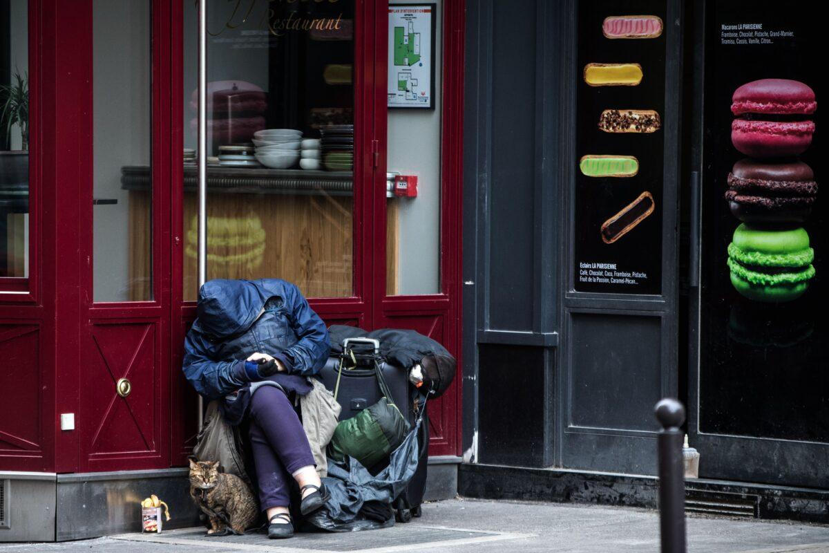A homeless person sits with his cat on a street in Paris on March 21, 2020. (Joel Sagat/AFP via Getty Images)