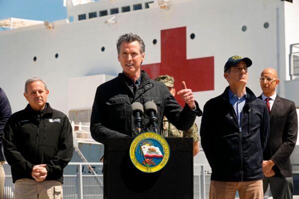 California Governor Gavin Newsom (C), flanked by (from L) Director Mark Ghilarducci, Cal OES, Los Angeles Mayor Eric Garcetti, and Dr. Mark Ghaly, Secretary of Health and Human Services, speaks in front of the hospital ship USNS Mercy after it arrived into the Port of Los Angeles on March 27, 2020. (Carolyn Cole/Pool/AFP via Getty Images)