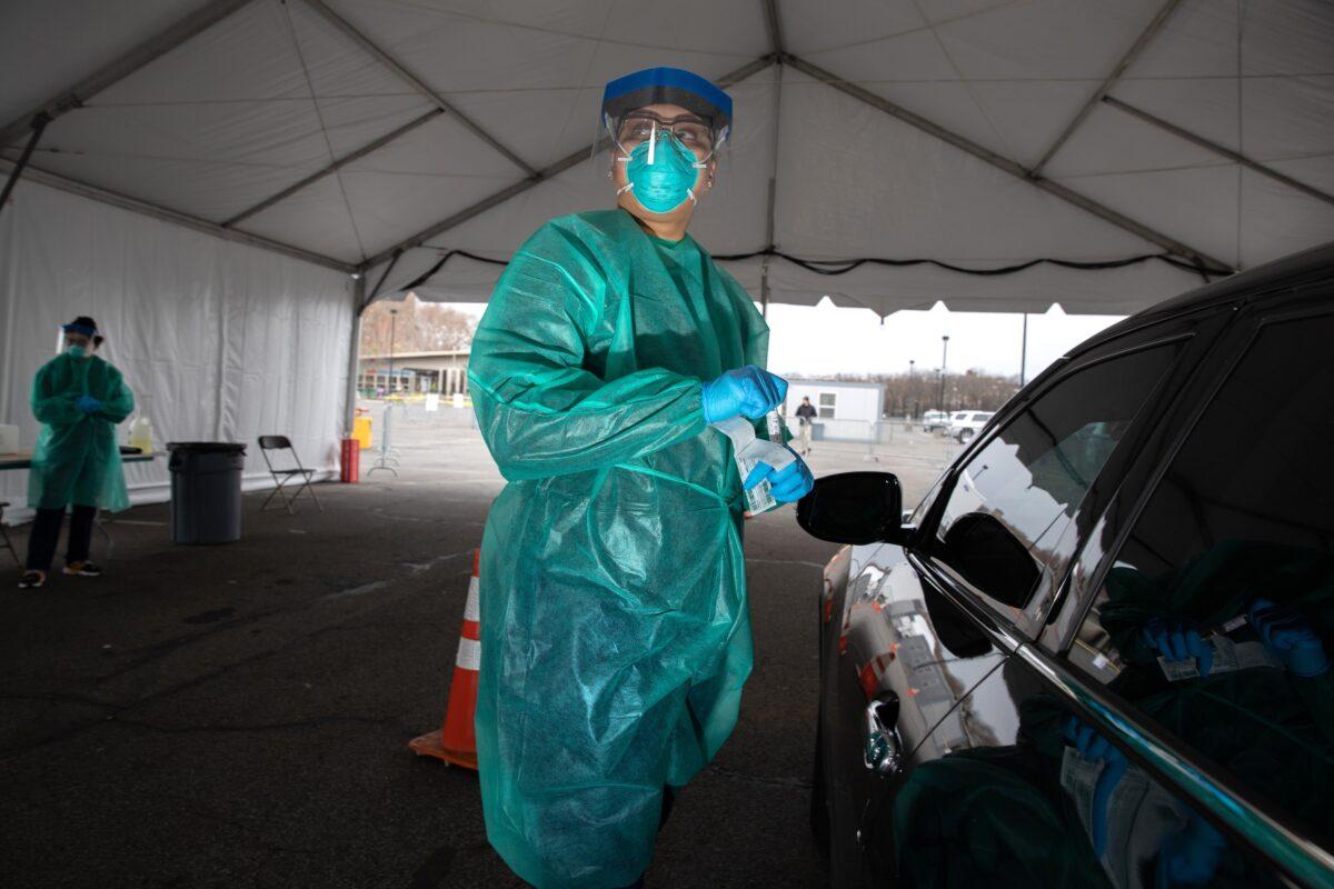 A doctor from SOMOS Community Care prepares to test a patient at a drive-thru testing center for COVID-19 at Lehman College in the Bronx, New York City on March 28, 2020. The center, opened March 23 at Lehman College, can test up to 500 people per day for the CCP virus. (John Moore/Getty Images)