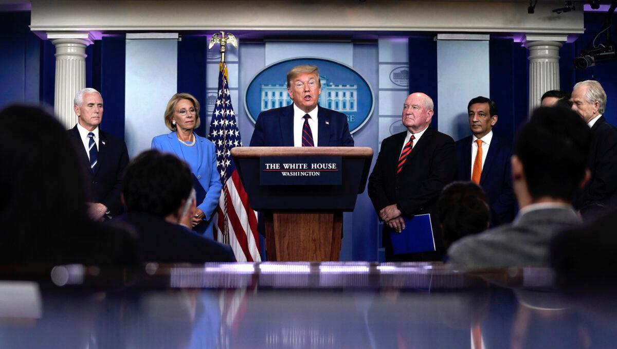 President Donald Trump speaks as Vice President Mike Pence, Secretary of Education Betsy DeVos, and Secretary of Agriculture Sonny Perdue look on during a briefing on the CCP virus pandemic in the press briefing room of the White House in Washington on March 27, 2020. (Drew Angerer/Getty Images)