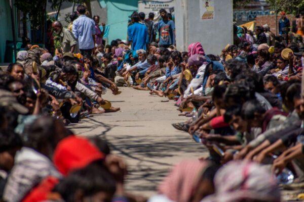 Indian migrant workers, daily wagers, laborers, and homeless people wait for food outside a government-run shelter as a nationwide lockdown continues in an attempt to stop the spread of the CCP virus in New Delhi, India, on March 28, 2020. (Yawar Nazir/Getty Images)