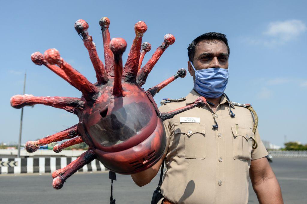 Police inspector Rajesh Babu poses with his CCP virus-themed helmet at a checkpoint during the government-imposed nationwide lockdown (ARUN SANKAR/AFP via Getty Images)