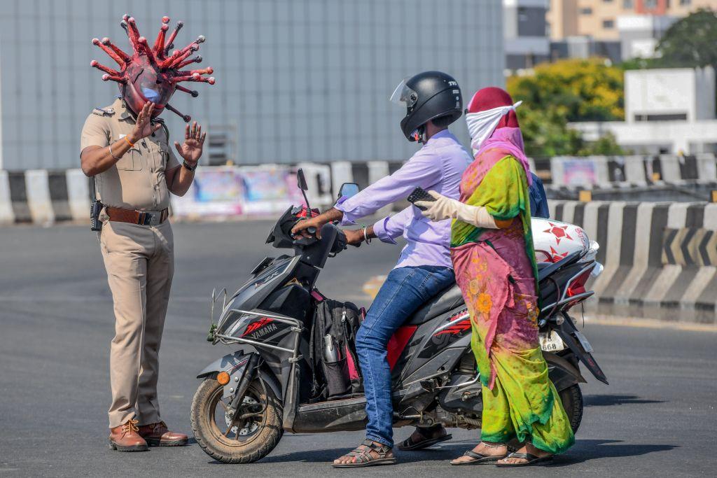 Police inspector Rajesh Babu wearing a CCP virus-themed headgear (a "coronavirus helmet") speaks to motorists during a government-imposed nationwide lockdown as a preventive measure against the COVID-19 disease in Chennai on March 28, 2020. (ARUN SANKAR/AFP via Getty Images)