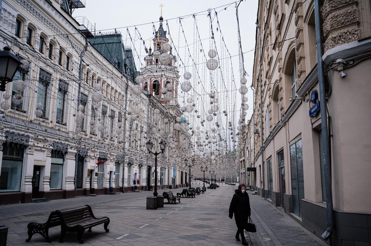 A woman wears a protective mask as she walks on a deserted street of downtown Moscow, Russia, on March 30, 2020. (Dimitar Dilkoff/AFP via Getty Images)