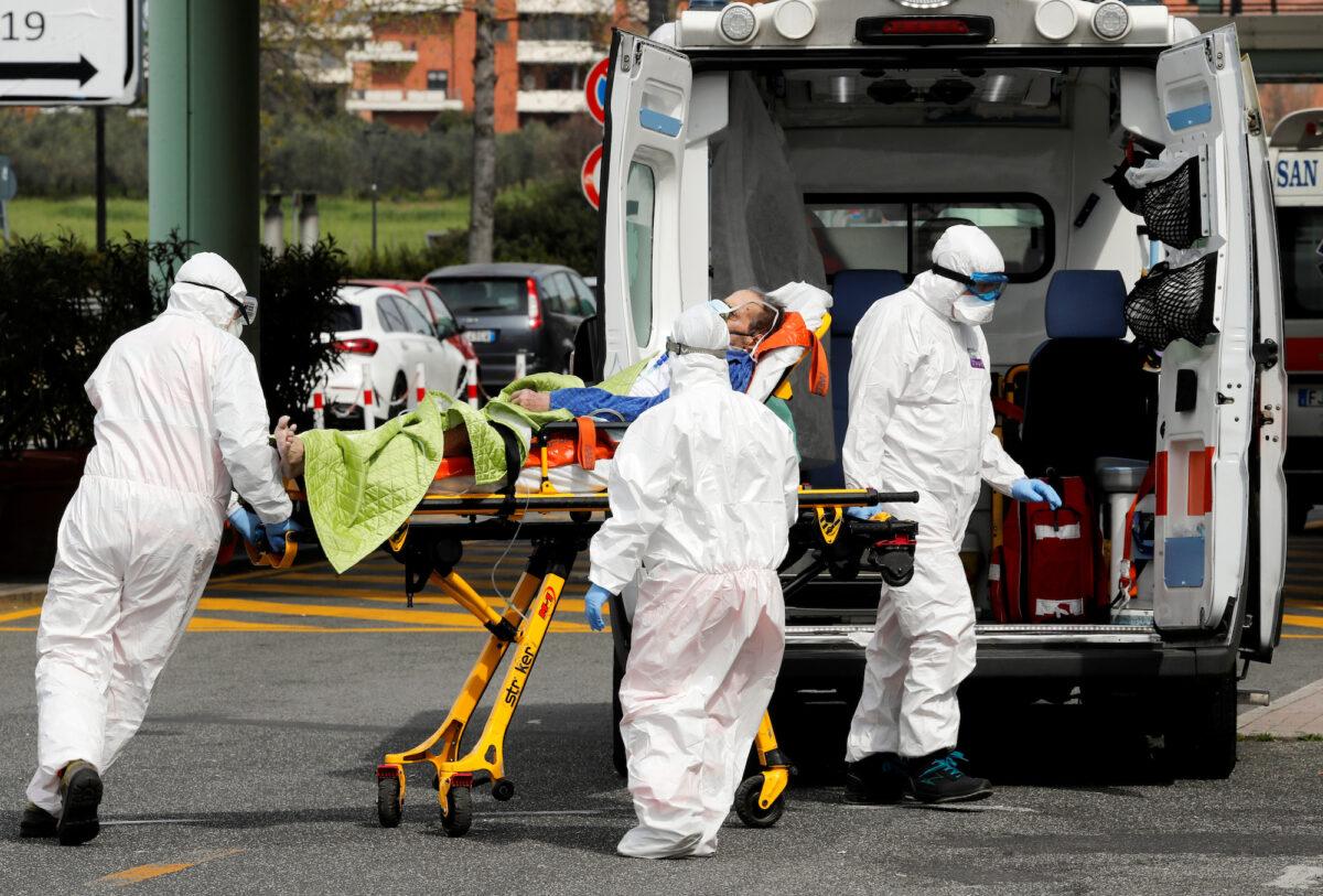 Medical responders in protective suits attend to a patient suspected of COVID-19 infection, in Rome, Italy, on March 30, 2020. (Reuters/Remo Casilli)