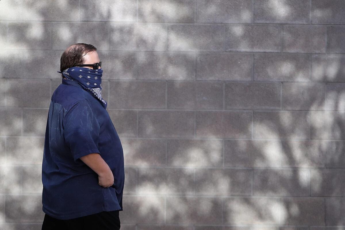 A man wearing a face mask walks downtown in Phoenix, Arizona on March 26, 2020. (Christian Petersen/Getty Images)