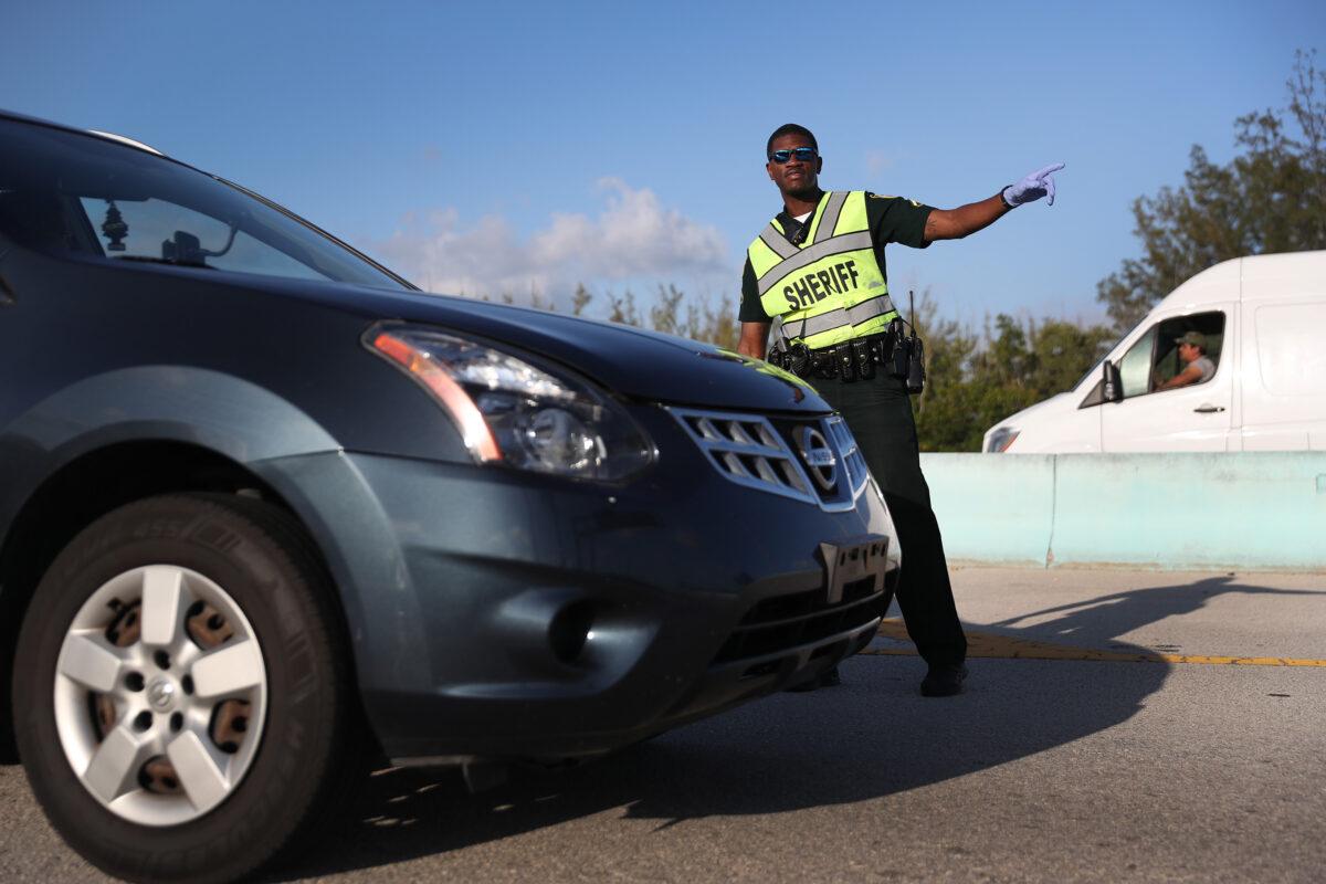 Monroe County Sheriff deputy Jamie Miller mans a checkpoint on U.S. 1 leading into the Florida Keys in Florida City, Florida on March 27, 2020. Monroe County administrators made the decision to prohibit tourists and only allow property owners and people who show they legitimately work in the Keys to pass through the roadblocks in an effort to stop the spread of COVID-19. (Joe Raedle/Getty Images)
