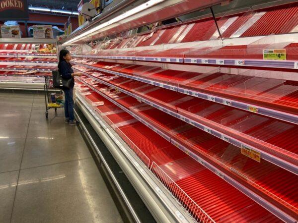 A shopper picks over the few items remaining in the meat section, as people stock up on supplies amid coronavirus fears, at a grocery store in Austin, Texas, on March 13, 2020. (Brad Brooks/File Photo/Reuters)