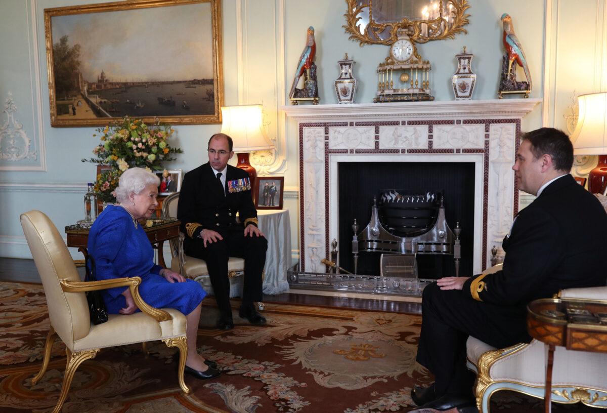 Queen Elizabeth II receives receives Commodore Stephen Moorhouse (right, outgoing Commanding Officer, HMS Queen Elizabeth) and Captain Angus Essenhigh (incoming Commanding Officer), during a private audience in the Queens Private Audience Room in Buckingham Palace in London on March 18, 2020. (Yui Mok - WPA Pool/Getty Images)