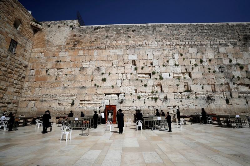 Worshippers pray in distance from each other at the Western Wall in Jerusalem's Old City amid CCP virus restrictions on March 26, 2020 (Ammar Awad/Reuters)
