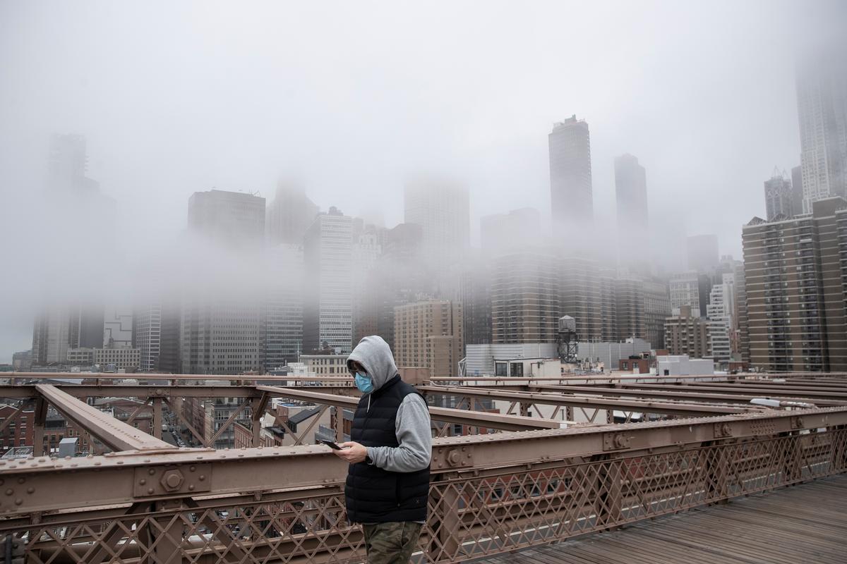A man wearing a mask walks the Brooklyn Bridge in the midst of the virus outbreak in New York City. (©Getty Images | <a href="https://www.gettyimages.com/detail/news-photo/man-wearing-a-mask-walks-the-brooklyn-bridge-in-the-midst-news-photo/1207839450?adppopup=true">Victor J. Blue</a>)