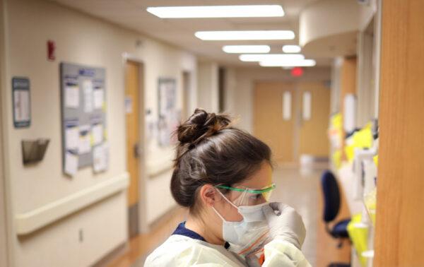 Nurses in the COVID-19 unit of MedStar St. Mary's Hospital check the fit of protective equipment before entering a patient's room in Leonardtown, Md., March 24, 2020. (Win McNamee/Getty Images)