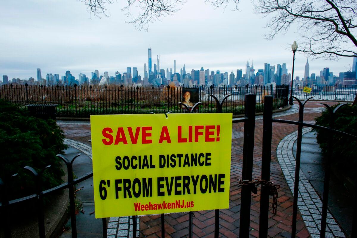 A newly installed sign encouraging social distancing to stop the spread of the CCP virus at a park in Weehawken, New Jersey, on March 28, 2020. (Kena Betancur/AFP via Getty Images)