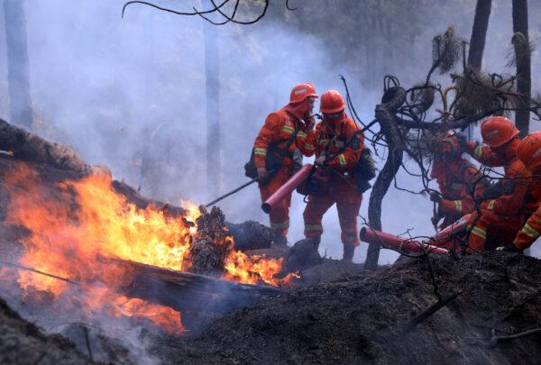 Firefighters work on extinguishing a forest fire that started near Xichang in Liangshan prefecture of Sichuan Province, China, on March 31, 2020. (China Daily via Reuters)